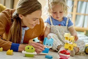 Family playing with LEGO building toys creating colourful structures.